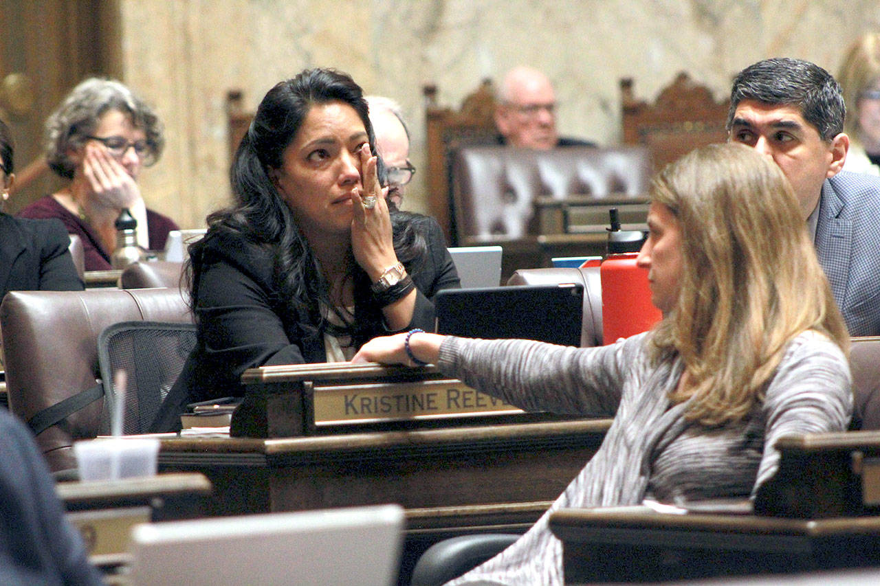 State Rep. Kristine Reeves, D-Federal Way, battles tears during the House floor debate on a bill to ban bump stocks, while her colleague Tana Senn, D- Mercer Island, turns to comfort her. (Taylor McAvoy/WNPA Olympia News Bureau)