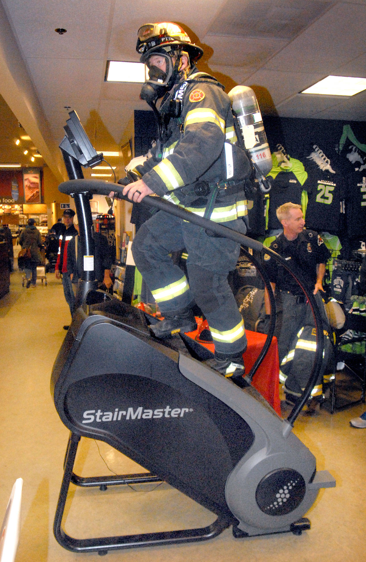 Port Angeles Fire Department Capt. Kelly Ziegler uses a stair-climbing exercise machine during a fundraising event at the Lincoln Street Safeway Food Drug store in Port Angeles on Saturday. A contingent of firefighters from the North Olympic Peninsula plan to take part in the annual Scott Firefighter Stairclimb on March 11 at the Columbia Center in Seattle to benefit the Lukemia Lymphoma Society. (Keith Thorpe/Peninsula Daily News)                                Keith Thorpe/Peninsula Daily News Port Angeles Fire Department Capt. Kelly Ziegler uses a stair-climbing exercise machine during a fund-raising event at the Lincoln Street Safeway Food & Drug store in Port Angeles on Saturday. A contingent of firefighters from the North Olympic Peninsula plan to take part in the annual Scott Firefighter Stairclimb on March 11 at the Columbia Center in Seattle to benefit the Lukemia & Lymphoma Society.
