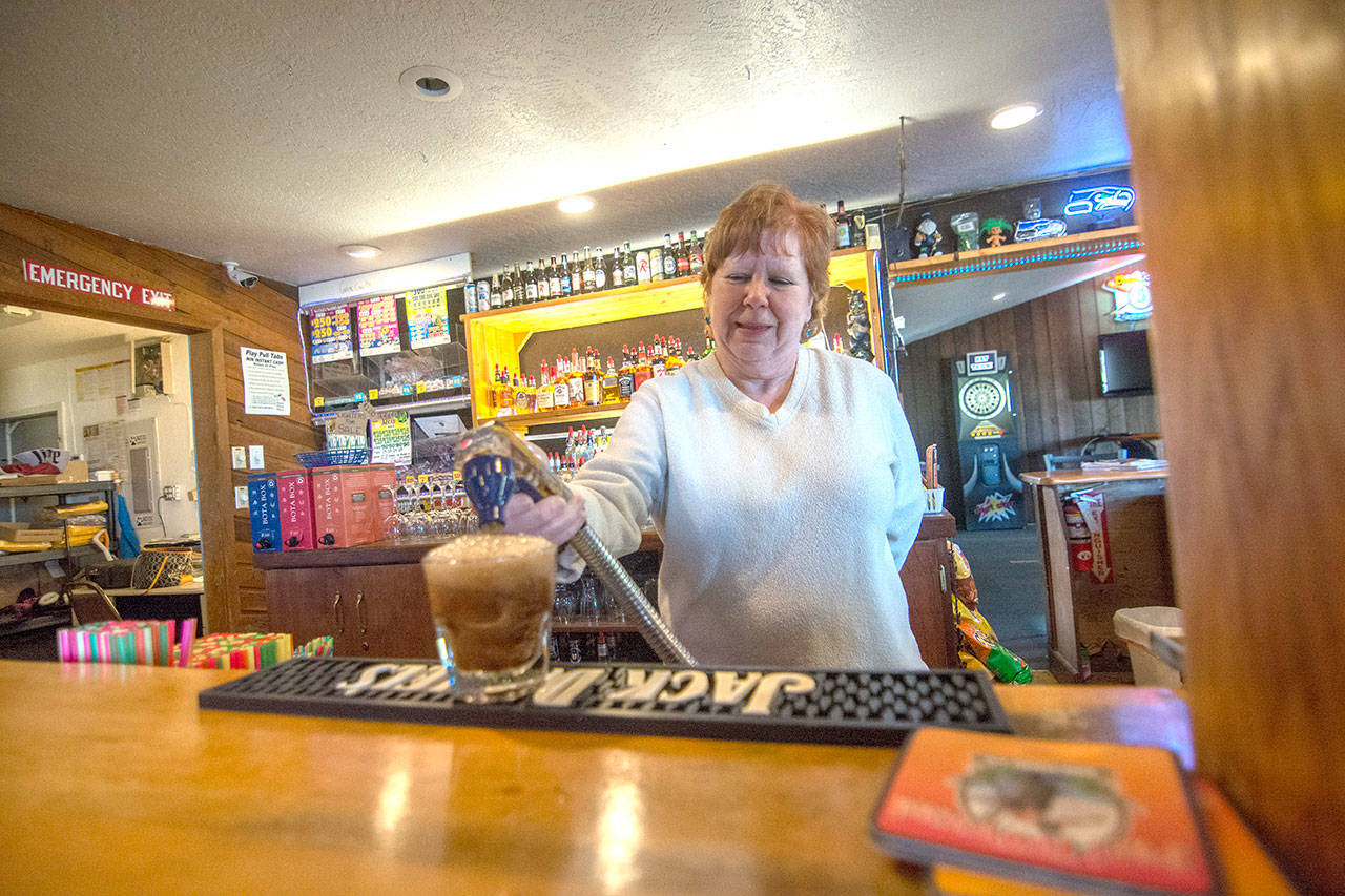 Elda Brandt, owner of The Dam Bar on U.S. Highway 101 west of Port Angeles, pours a drink Monday. The bar is facing legal penalties for allegedly allowing copyrighted songs to be sung on karaoke night without a music industry license. (Jesse Major/Peninsula Daily News)