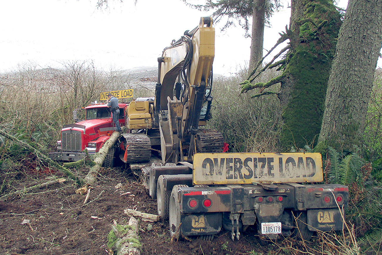Driver unharmed when truck, excavator go 100 feet down embankment on Highway 112