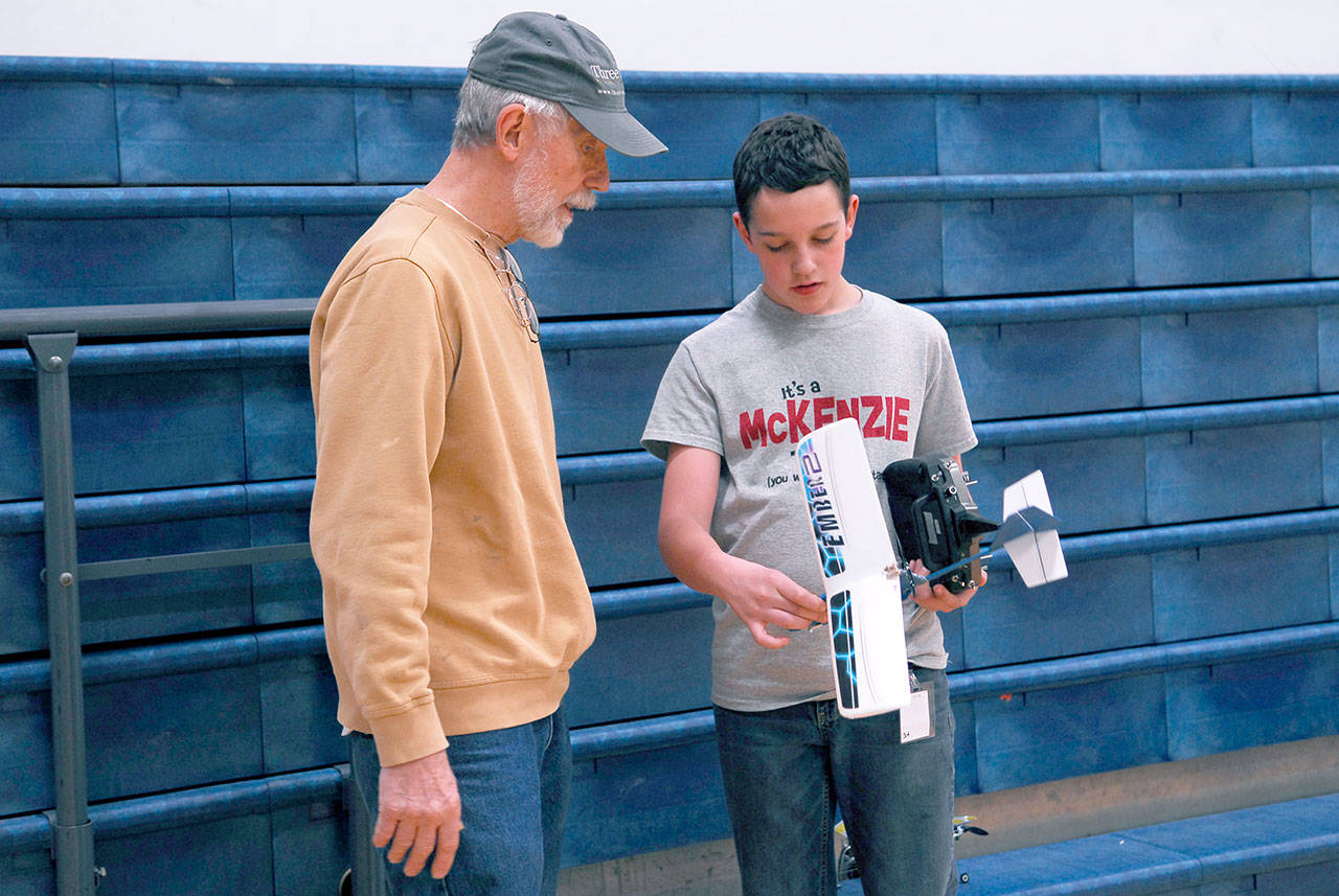 Blue Heron Middle School student Joshua McKenzie listens to instruction from mentor Robert Davis during a You Can Fly! after-school session. The seventh-grader plans to continue learning about aeromodeling. Davis said the model is based on a real aerobatic plane, the Ran’s S-10 designed by Randy Schlitter. (Jeannie McMacken/Peninsula Daily News)