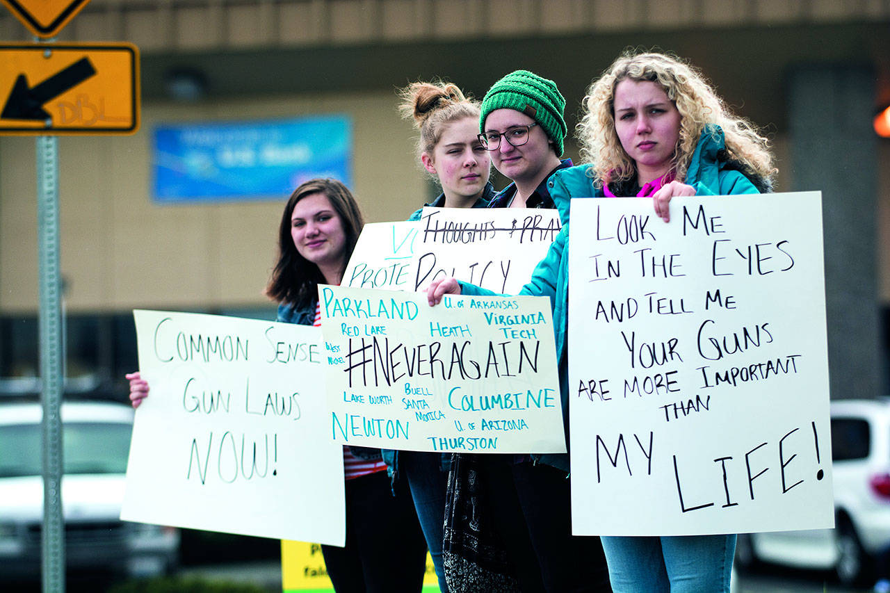 Port Angeles High School students, from left, Gillian Elofson, 17, Charlotte Hertel, 16, Darbey Martin, 17, and Emily Menshew, 17, demonstrate outside a gun and knife show at the Port Angeles Masonic Temple calling for gun control. (Jesse Major/Peninsula Daily News)