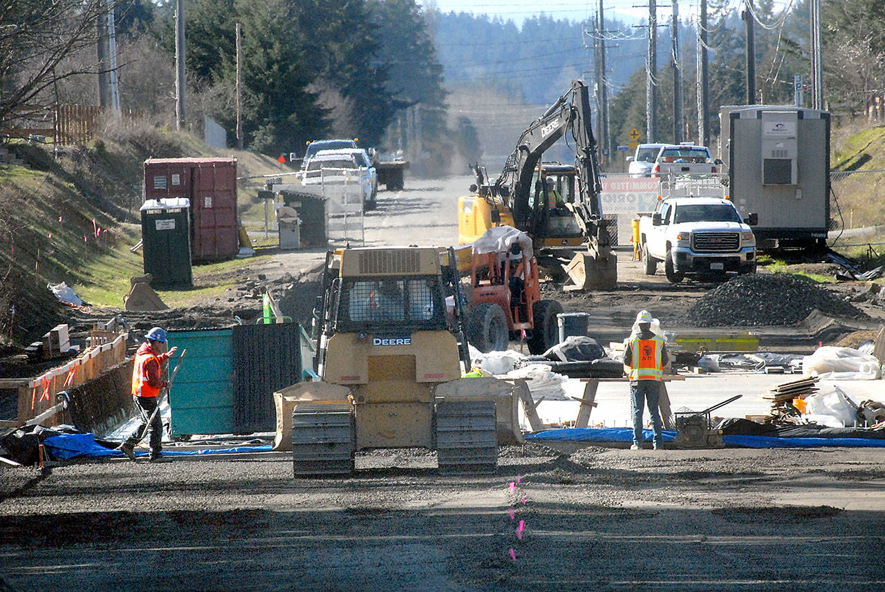 Construction crews work Tuesday to build the approaches to a new bridge on Old Olympic Highway over McDonald Creek east of Port Angeles. (Keith Thorpe/Peninsula Daily News)