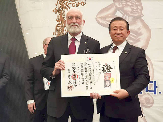Port Angeles’ Robert Nicholls receives the certificate of 9th dan taekwondo Grandmaster from Jidokwan President Lee Sung Wan during a ceremony in Seoul, South Korea earlier this month.