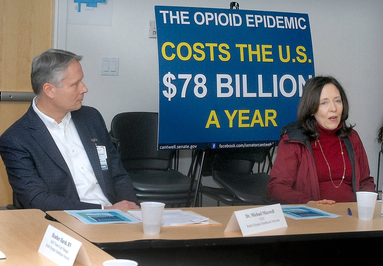 Dr. Michael Maxwell, CEO of the North Olympic Healthcare Network, left, listens as Sen. Maria Cantwell speaks during a roundtable discussion in Port Angeles on Saturday about opioid addiction and abuse. (Keith Thorpe/Peninsula Daily News)