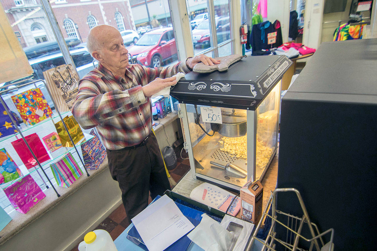 Rudy Hiener wipes off the popcorn-maker at Bay Variety in Port Angeles on Tuesday. (Jesse Major/Peninsula Daily News)