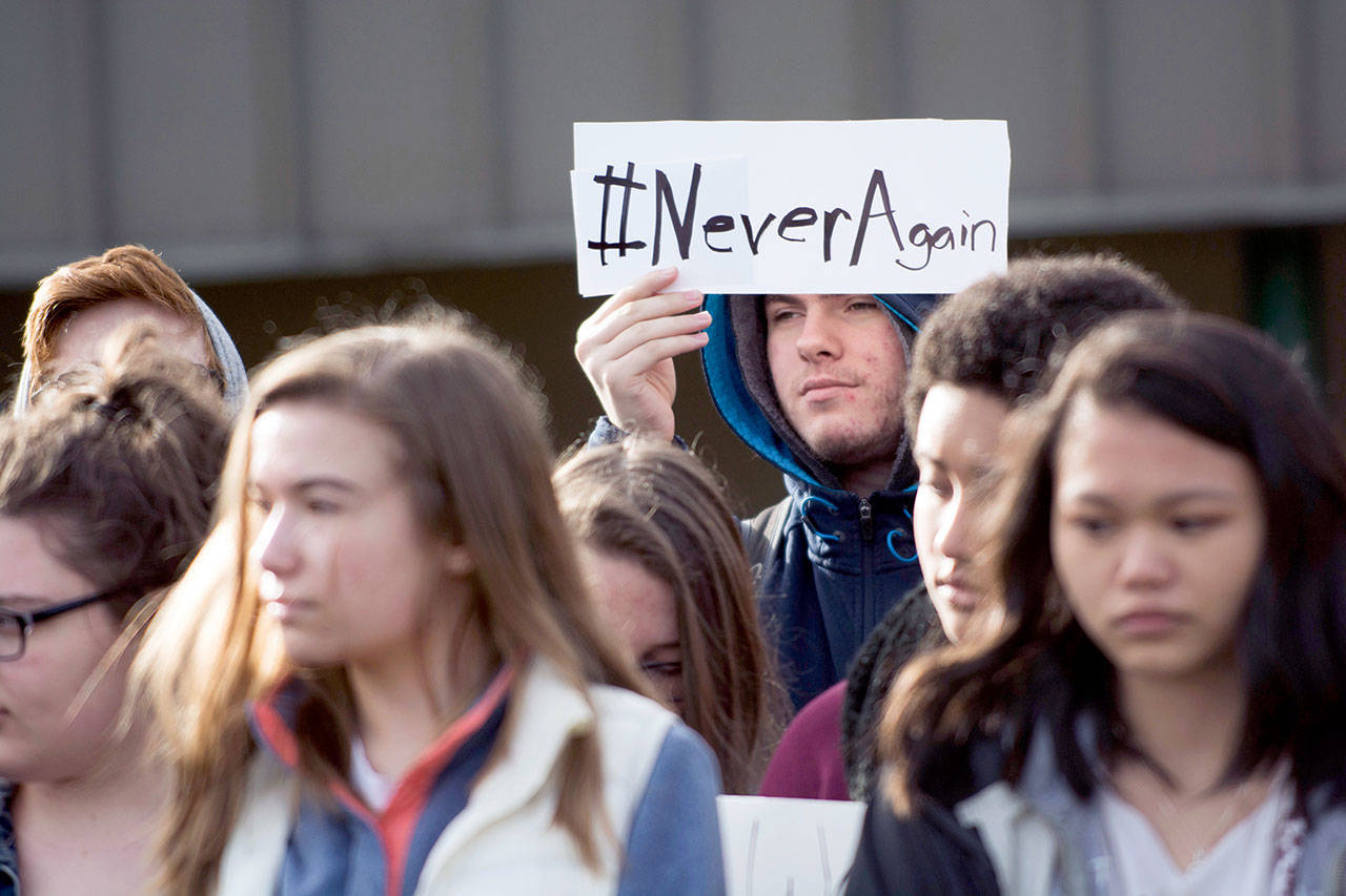 A student at Port Angeles High School holds a sign during the National School Walkout at Port Angeles High School on Wednesday. (Jesse Major/Peninsula Daily News)