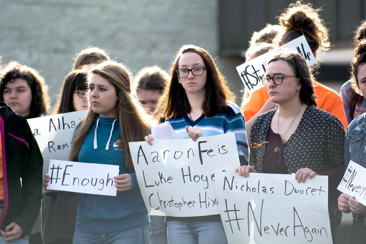 Students at Port Angeles High School hold signs during the National School Walkout at Port Angeles High School on Wednesday. (Jesse Major/Peninsula Daily News)