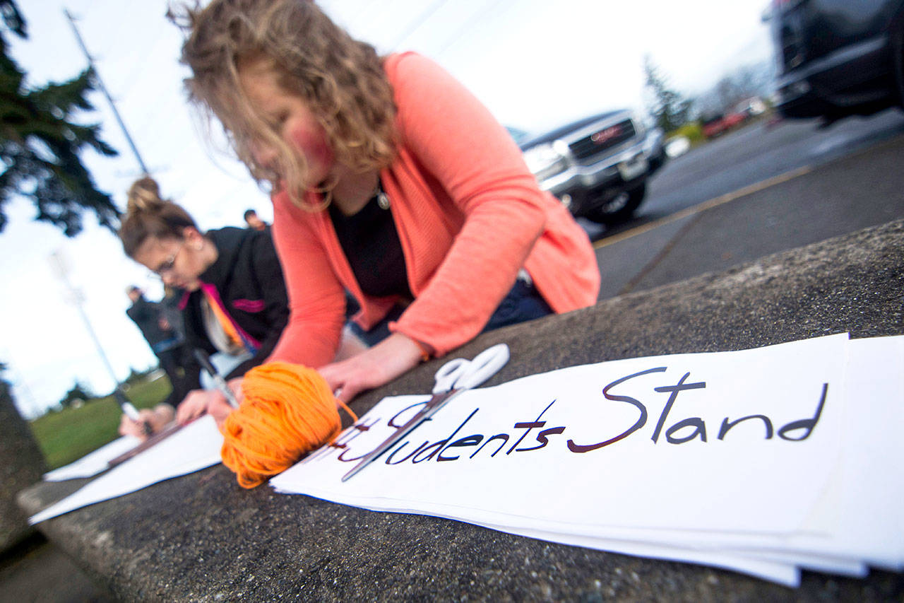 Students make signs before the walkout at Port Angeles High School on Wednesday. (Jesse Major/Peninsula Daily News)