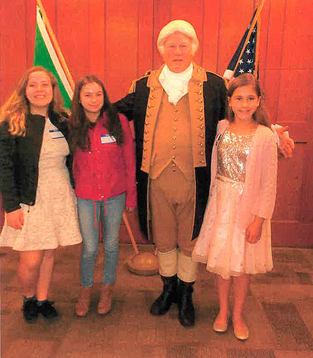 Joining George Washington (Vern Frykholm) at a DAR George Washington Tea in Port Angeles are, from left, essay contest-winning students Olivia Preston, Reice Elsasser-Donaldson and Kendall Mitchell.
