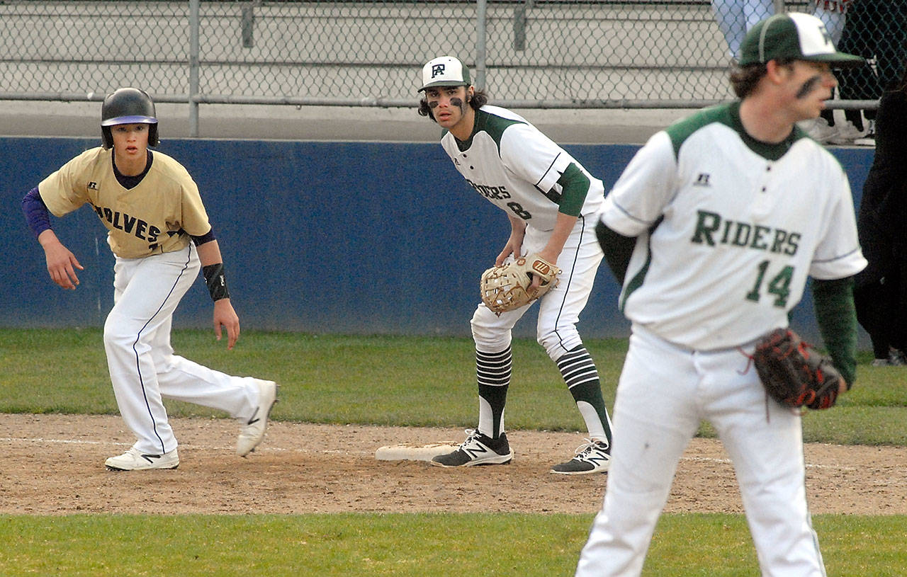 Sequims Michael Young, left, takes a lead off as he watches Port Angeles pitcher Brady Shimko, right, as Roughrider first baseman Bo Bradow waits for delivery in the first inning on Wednesday evening at Port Angeles Civic Field. Keith Thorpe/Peninsula Daily News