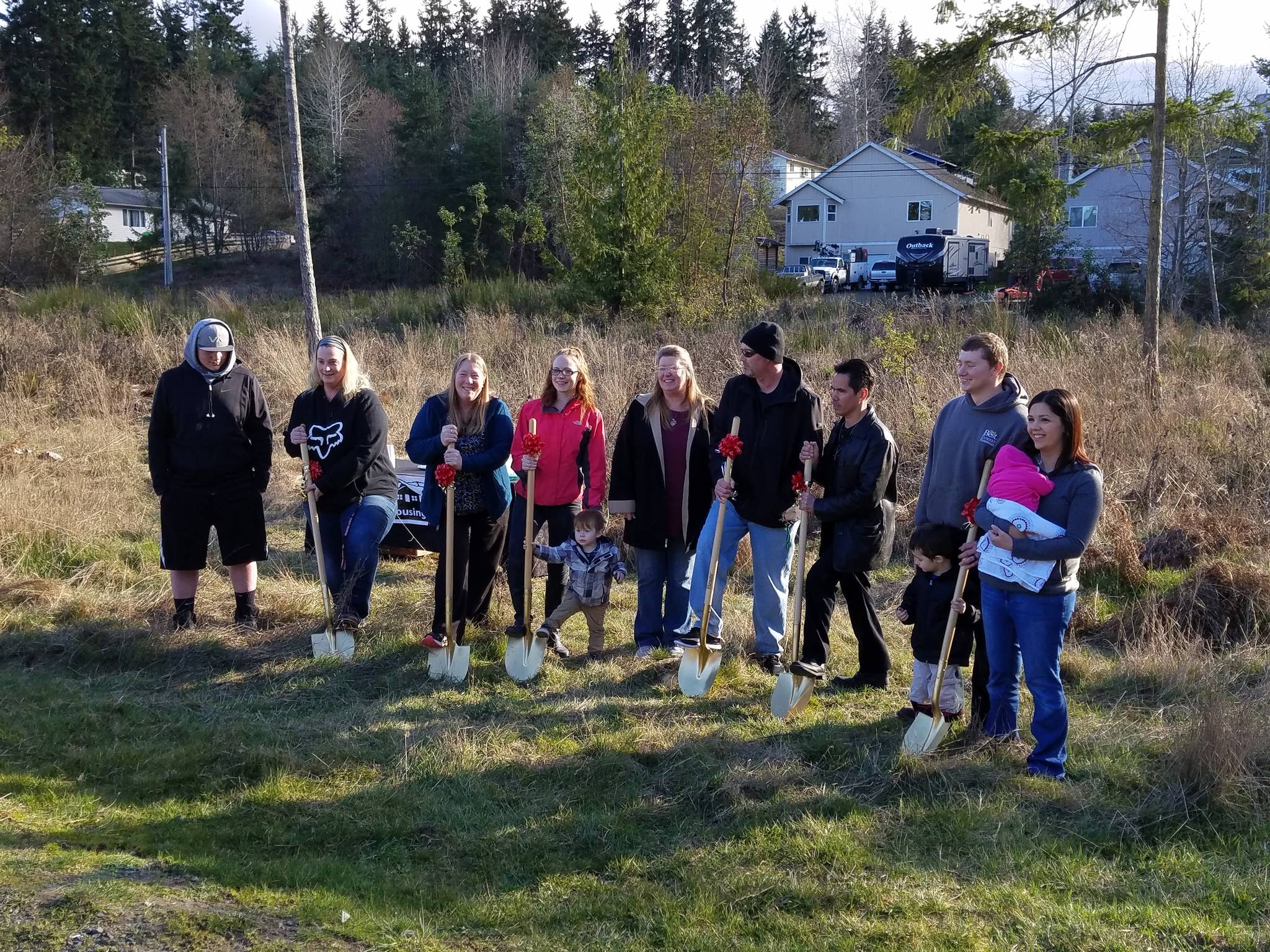 Families who broke ground for their homes at Cedarglen Terrace I are, from left, Lucas Meyer and Ann Rider; Betsy Fullerton; Chaleena Simmons, with her son doing the shoveling; Christy and Bret Niles; Francisco Gloria; and Ryan Heskett and Breana Lovik with their son and daughter.