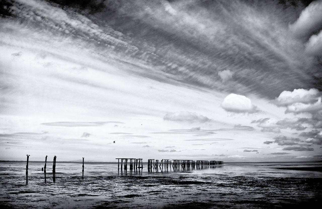 “Clouds and Pilings” by Ken Dvorak is on exhibit at Blue Whole Gallery.