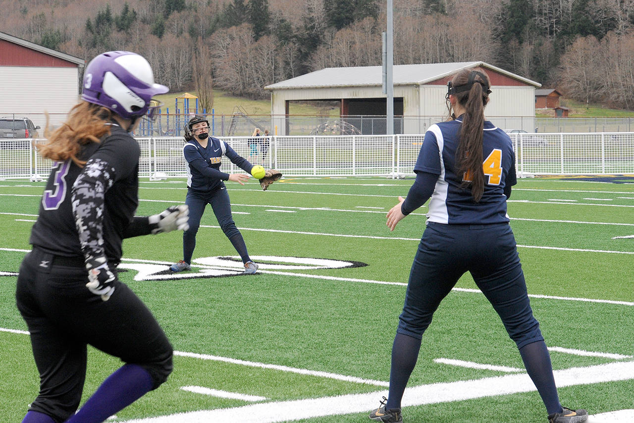 Lonnie Archibald/for Peninsula Daily News                                Quilcene’s Erin Macedo, left, was safe at first as Forks second baseman Myah Rondeau throws to first baseman Natalie Lausche during the first softball game played on the artificial turf at Spartan Stadium in Forks.