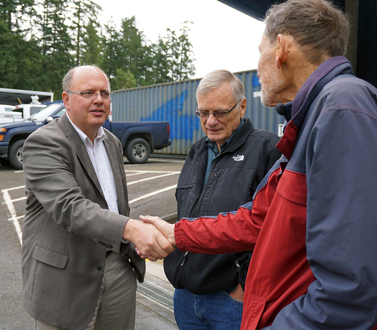 Jefferson County Public Utillity District’s General Manager Larry Dunbar, left, greets PUD Citizen Advisory Board Member Peter Lauritzen while Bill Kaune of Kala Point looks on during the PUD’s fifth anniversary celebration at the utility’s headquarters south of Port Townsend. (Jefferson County PUD)