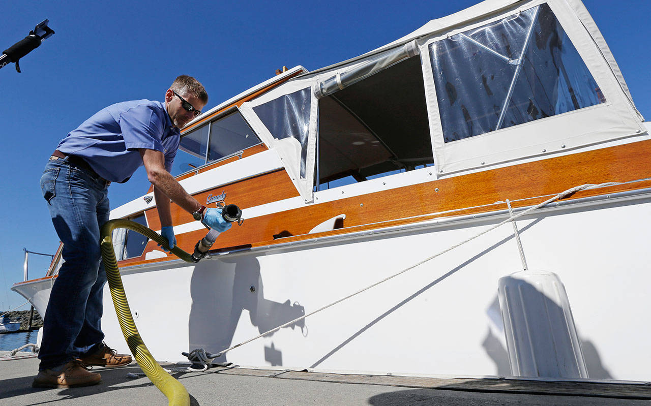 In this July 21, 2016, file photo, Todd Powell, of Federal Way demonstrates to reporters how to pump out the sewage holding tank on his boat at a pump-out station at the Des Moines Marina in Des Moines. (Ted S. Warren/The Associated Press)