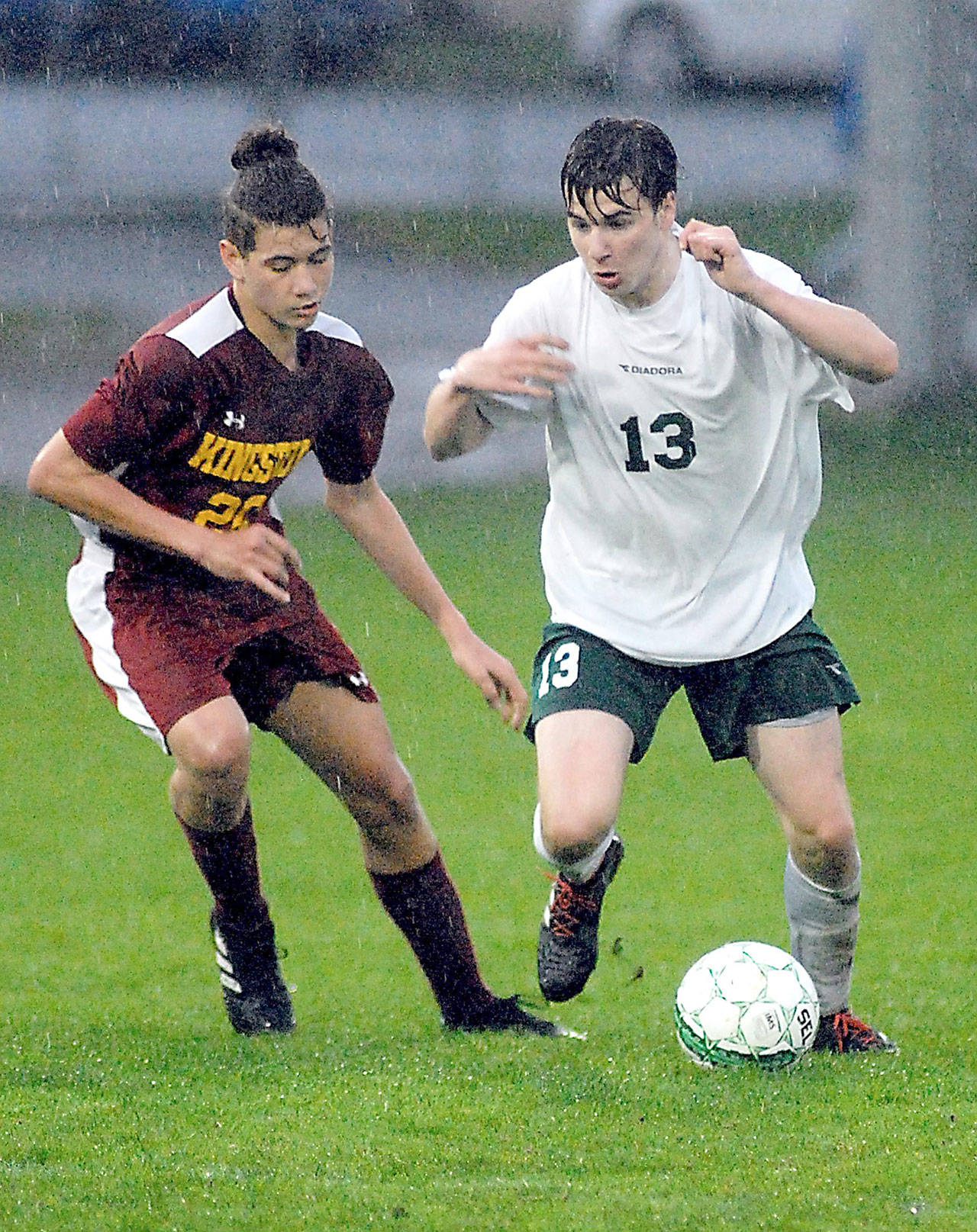 Keith Thorpe/Peninsula Daily News Kingston’s Judah Andrews, left, and Port Angeles’ Stuart Methner battle for the ball in a rain-soaked first half on Friday evening at Port Angeles Civic Field.