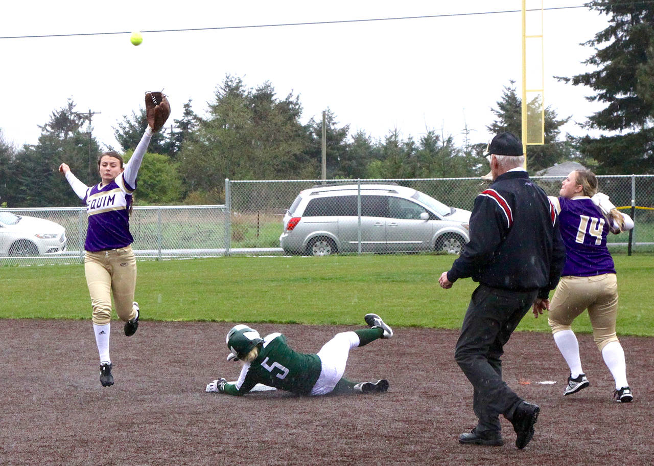 Sequim’s Bobbi Sparks, left, is unable to catch a high throw to second base on a steal attempt by Port Angeles’ Natalie Steinman (5). Steinman slid past the base on the slippery artificial turf infield and Sequim’s Shelby Jones (14) caught the overthrown ball and tagged out Steinman.                                Dave Logan/for Peninsula Daily News
