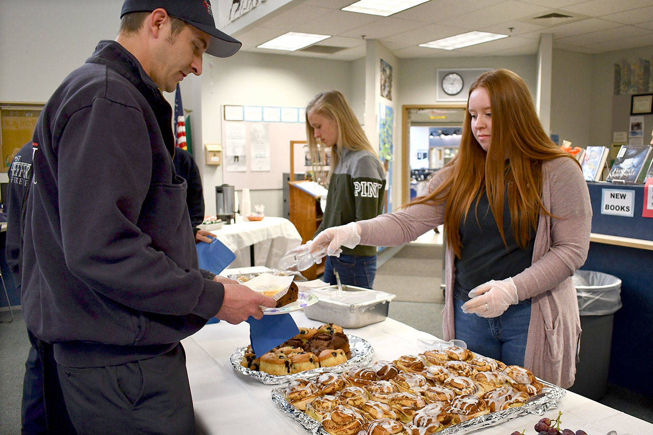 East Jefferson Fire-Rescue resident volunteer EMT Andrew Raney participated in a special breakfast meeting for first responders last Friday hosted by the Chimacum School District. Junior class members Rachel Matthes and Nina Haddenham were two of the volunteer servers for the event. (Jeannie McMacken/Peninsula Daily News)