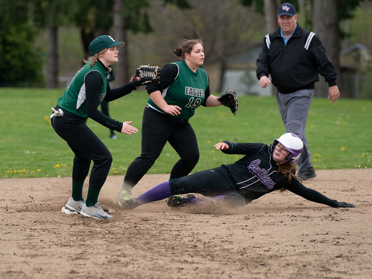 Quilcene’s Madison Coffey steals second base ahead of the throw to Evergreen Lutheran’s Lyndsey Lee and Olivia Baker, 19, during a game in Qulcene on Friday. (Steve Mullensky/for Peninsula Daily News)
