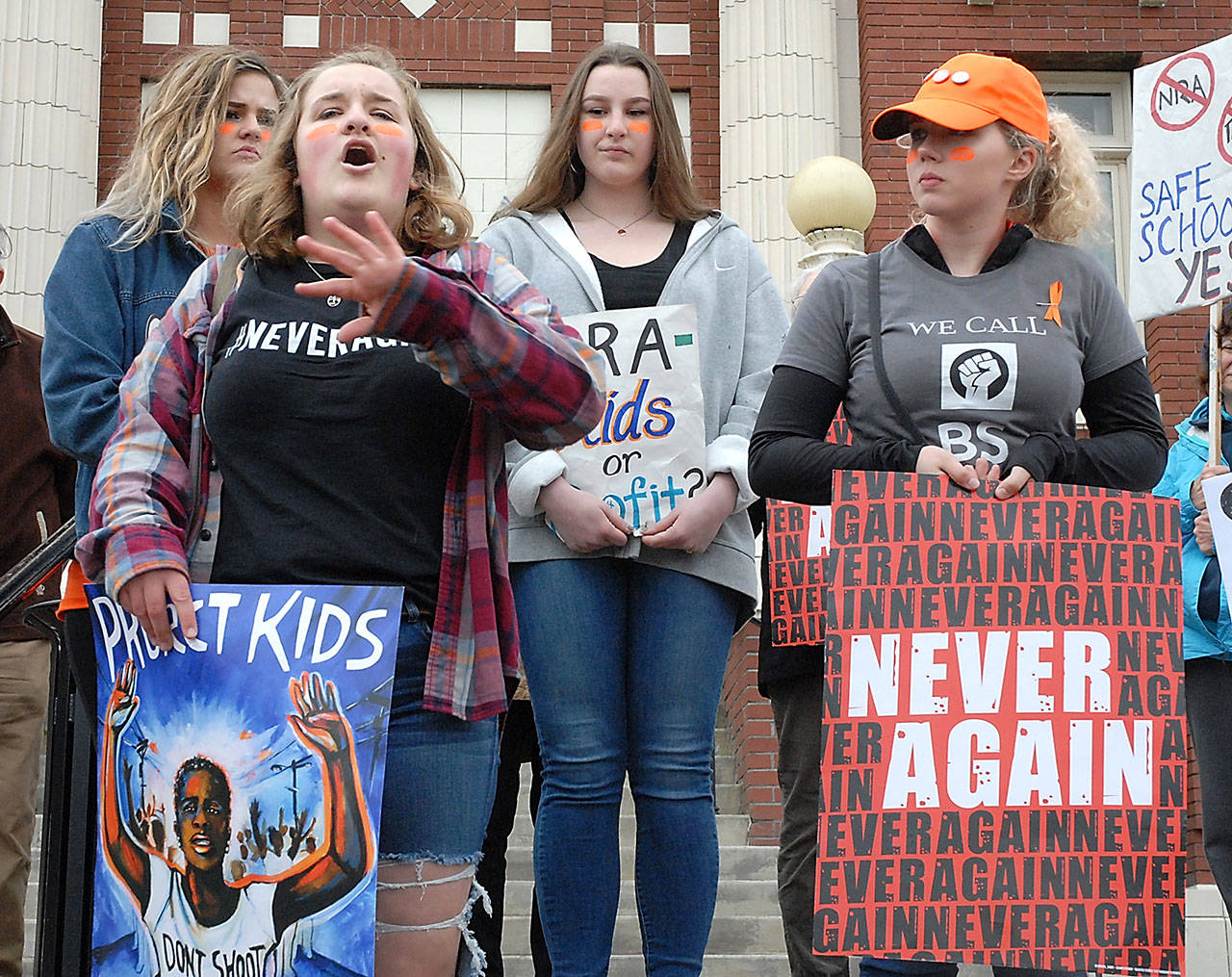 Port Angeles High School student Elizabeth Watkins, 18, second from left, talks about active-shooter drills at her school during an march and rally for sensible gun laws on Friday. Among those accompanying Watkins on the Clallam County Courthouse steps were fellow students, from left, Lily Robertson, 17, Jera Taylor, 16, and Emily Menshew, 17. (Keith Thorpe/Peninsula Daily News)