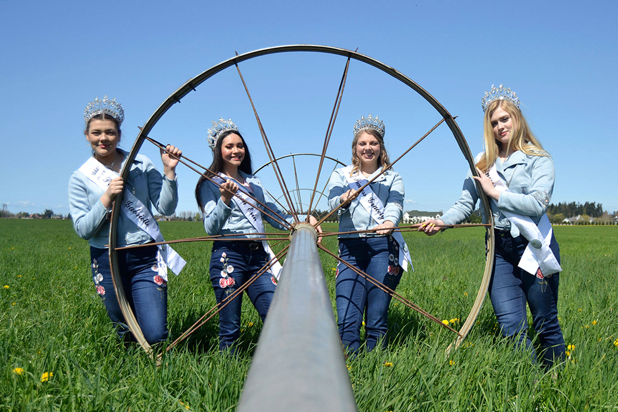 Sequim Irrigation Festival royalty, from left, Princess Gabi Simonson, Queen Erin Gordon, Princess Gracelyn Hurdlow and Princess Eden Batson stand by a sprinkler on the Dick Family Farm during a photo shoot for the festival’s programming. (Matthew Nash/Olympic Peninsula News Group)