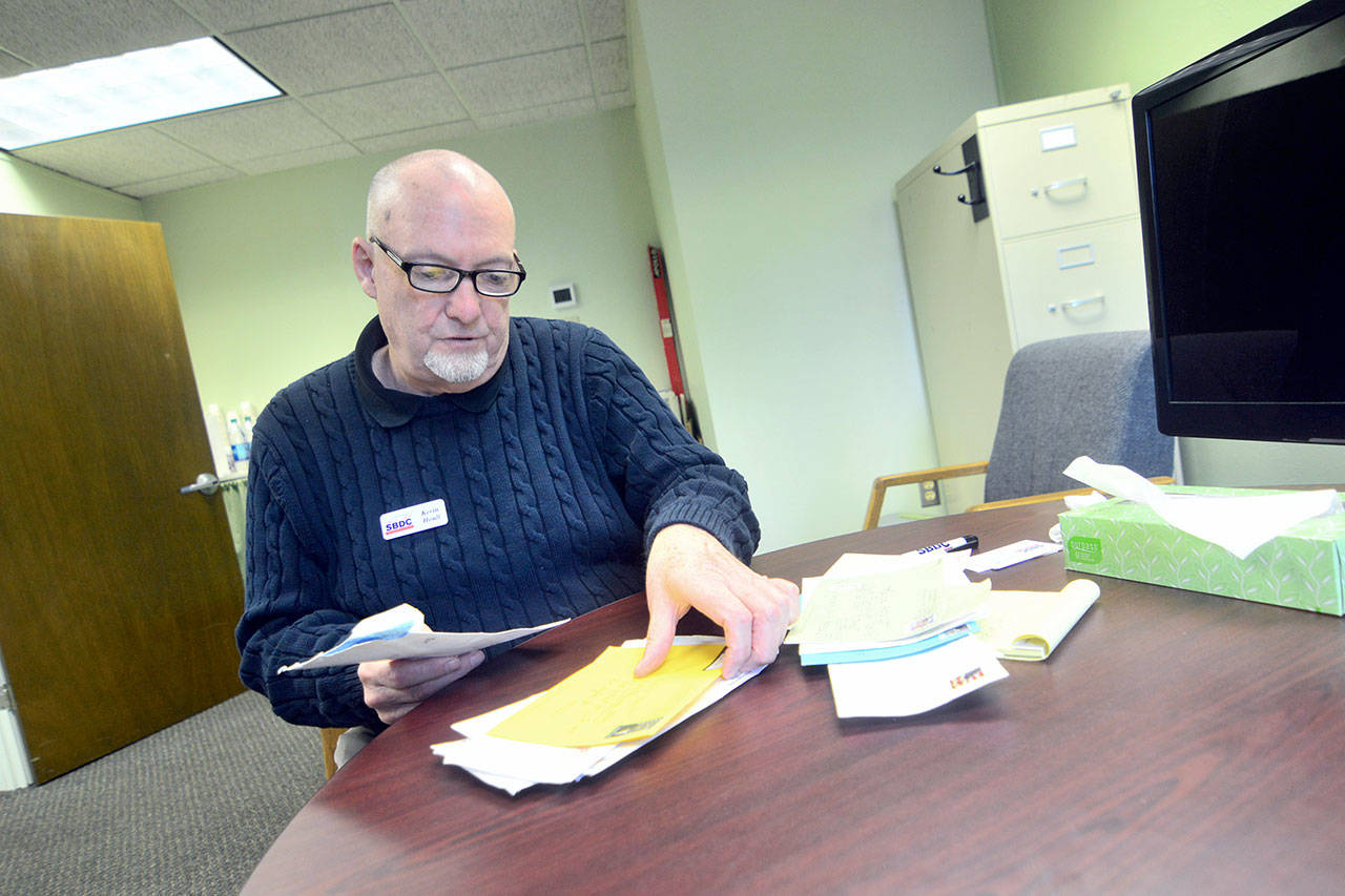Kevin Hoult, certified business adviser with the North Peninsula Small Business Development Center, looks through three years worth of mail that was recently delivered by the U.S. Postal Service. (Jesse Major/Peninsula Daily News)