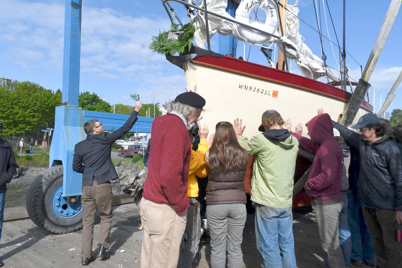 The Felicity Ann is blessed by minister/boatbuilder Simon de Voil during its launch ceremony at Point Hudson on Tuesday. The historic wooden boat was restored by the Northwest School of Wooden Boatbuilding and the Community Boat Project by volunteer craftspeople. (Jeannie McMacken/Peninsula Daily News)