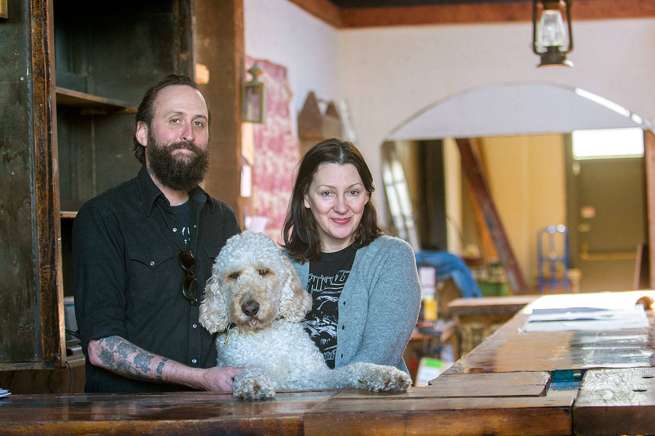 Mat Brooke, his wife, Lisa Jack, and their dog Sherman stand at the bar of The Spruce, a restaurant the couple is preparing to open in downtown Port Angeles early this summer. (Jesse Major/Peninsula Daily News)