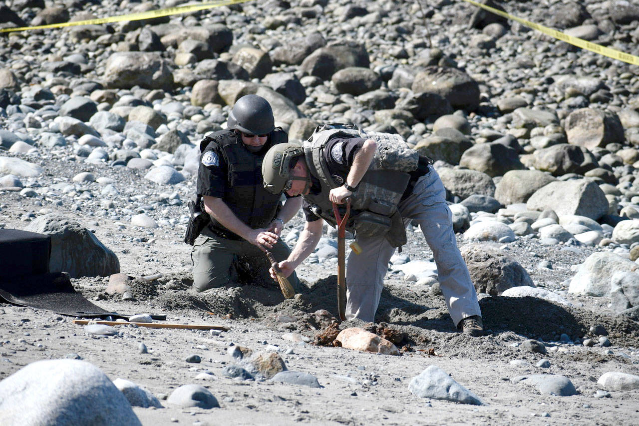 State Patrol Bomb Squad technicians Keith Nester and John Ryan process the scene at North Beach where a metal object believed to be some kind of World War II device was found Tuesday afternoon. Upon further review, it was decided the object was of an undetermined nature and a piece of it was taken to the state lab for analysis. (Jeannie McMacken/Peninsula Daily News)