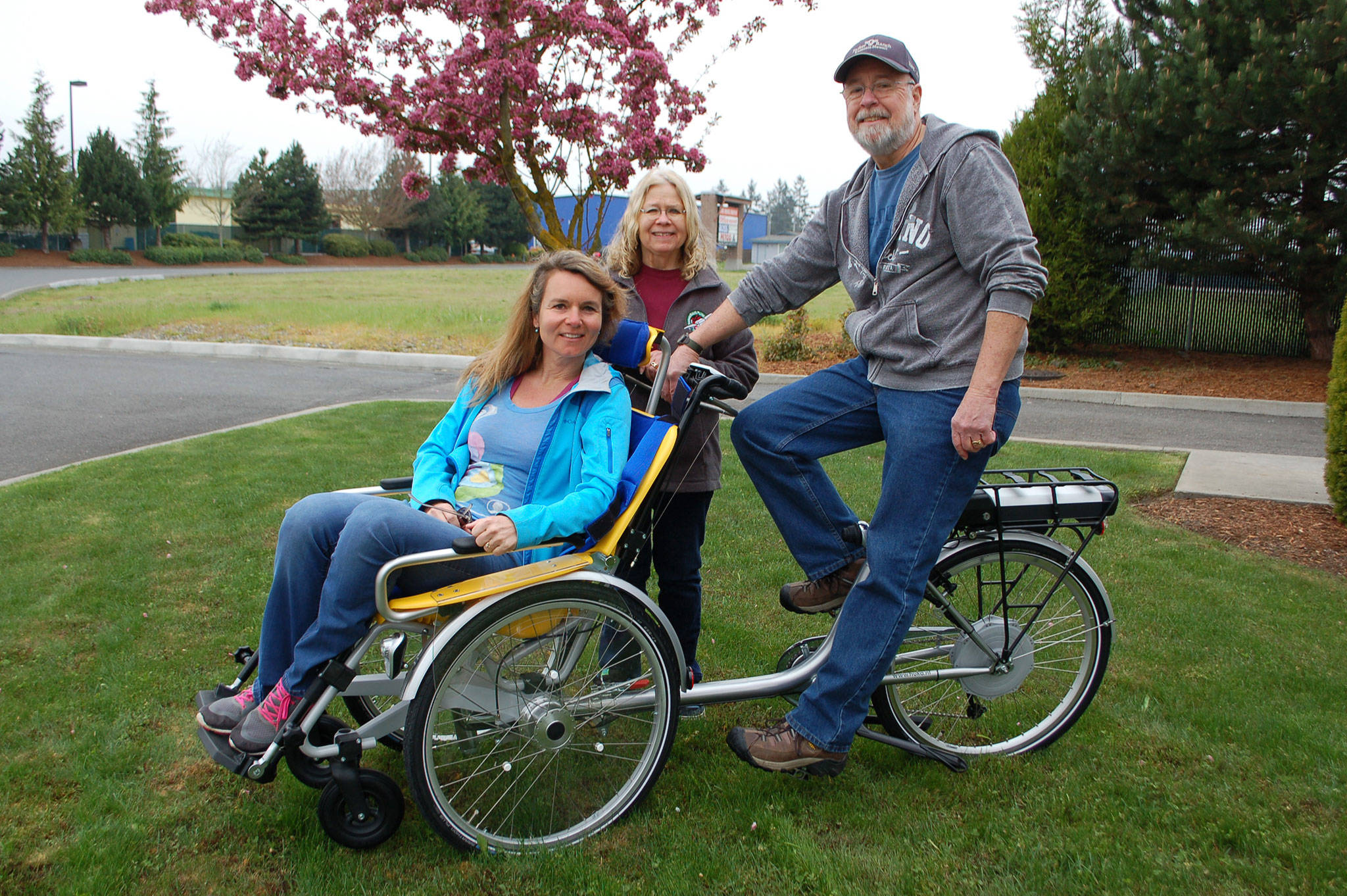 The Sequim Wheelers founder and Board president Nicole Lepping, foreground, and Board members Susan Hedding and Paul Muncey take its first wheelchair bike out for a spin near Ben’s Bikes in Sequim. Erin Hawkins/Olympic Peninsula News Group