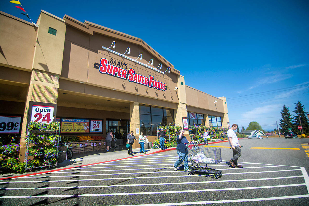 Customers return to their vehicles after shopping at Saar’s Super Saver Foods in Port Angeles during its opening day on Wednesday. A grand opening celebration is planned for Saturday. (Jesse Major/Peninsula Daily News)