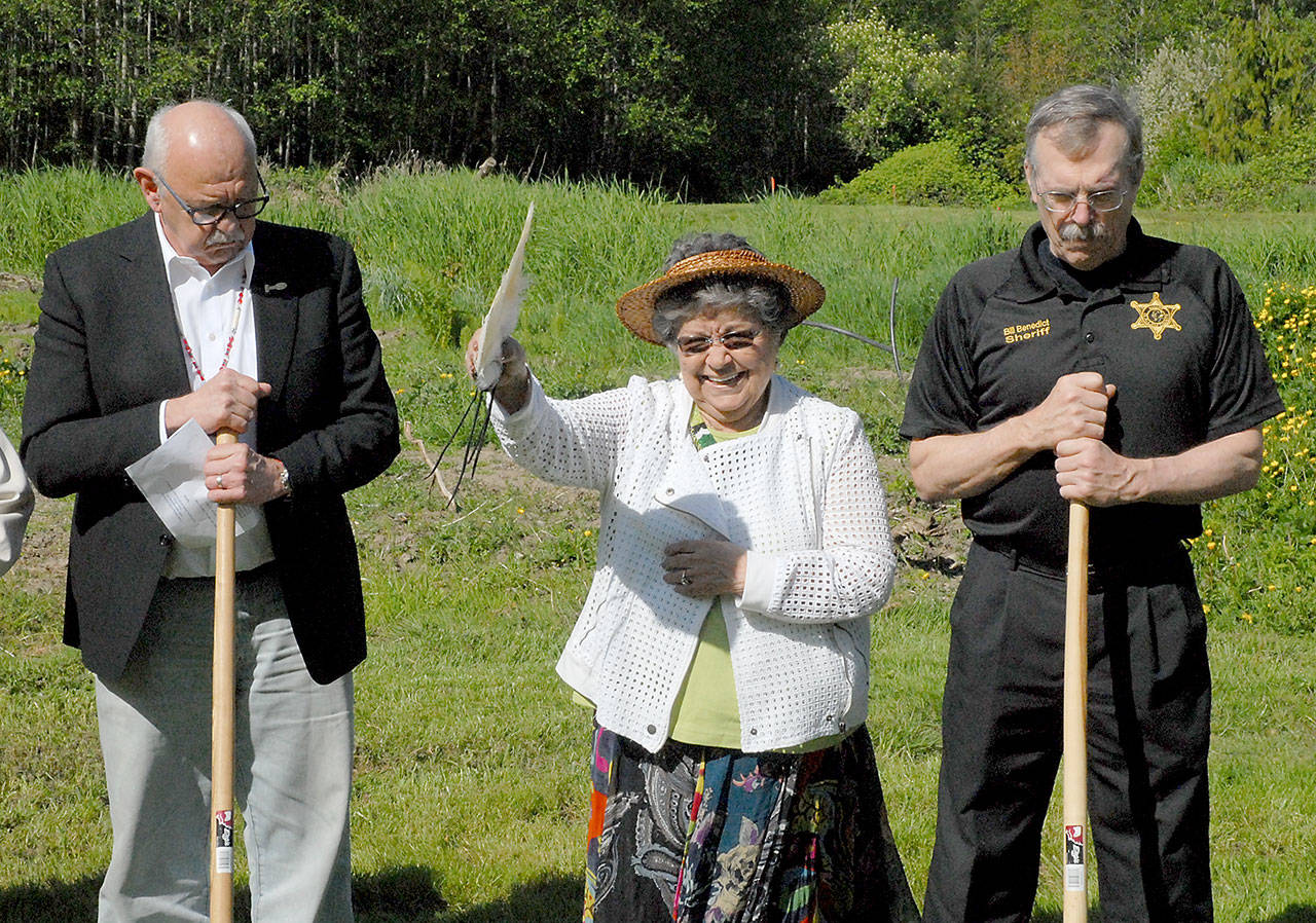 Jamestown S’Klallam tribal elder Elaine Grinnell, center, gives a blessing over the site of the tribe’s future public safety and justice center in Blyn while surrounded by the tribal council Chairman Ron Allen, left, and Clallam County Sheriff Bill Benedict on Saturday. (Keith Thorpe/Peninsula Daily News)