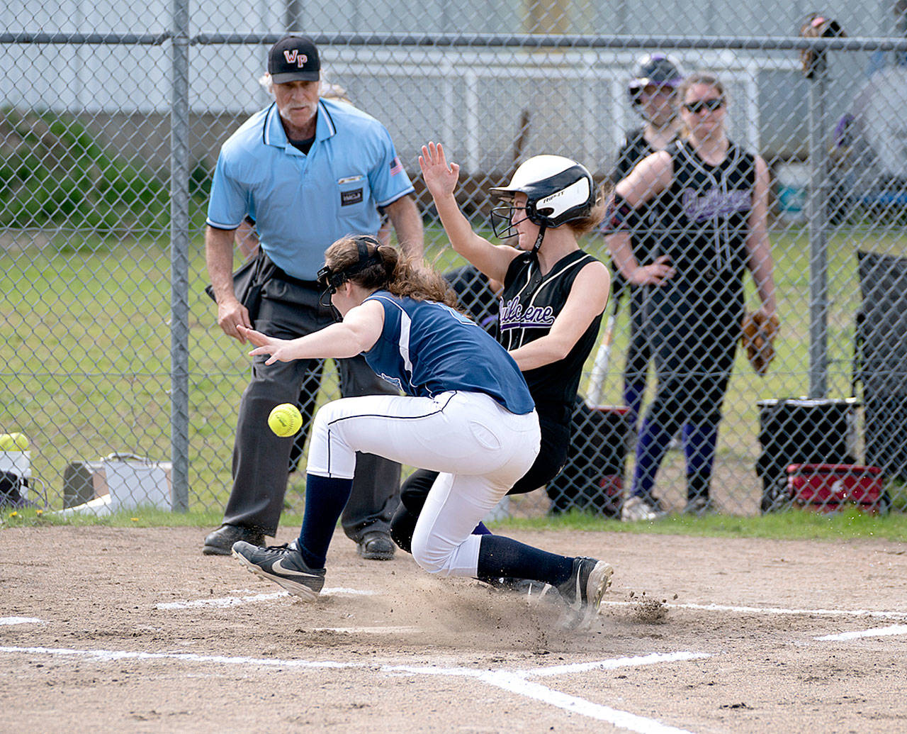 Quilcene’s Kourtney Benek collides with Rainier Christian catcher, Kendra Dieber and scores a run in the 1B League Championship game in Quilcene on Friday. (Steve Mullensky/for Peninsula Daily News)