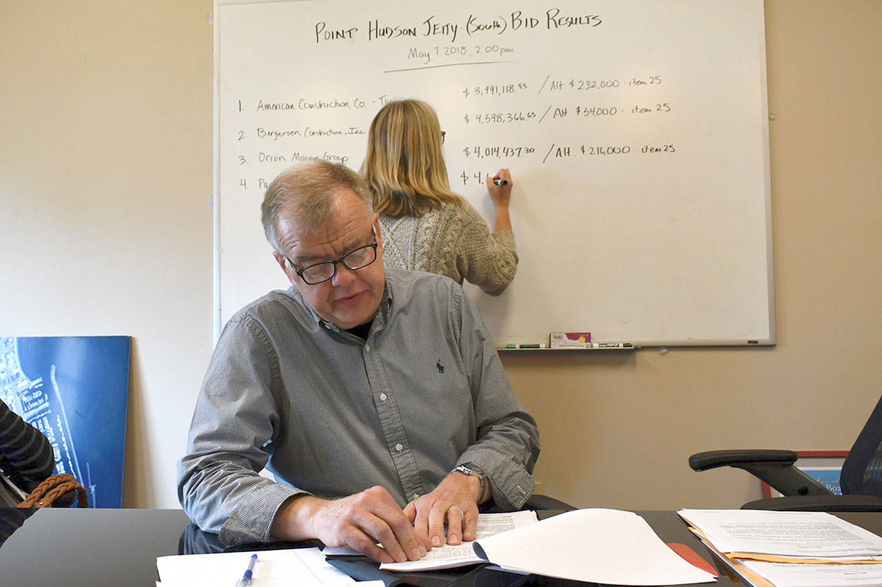 Port of Port Townsend Director of Planning Eric Toews reads the sealed bids for the Point Hudson South Jetty Project as executive assistant Sue Nelson notes the results on the white board. (Jeannie McMacken/Peninsula Daily News)