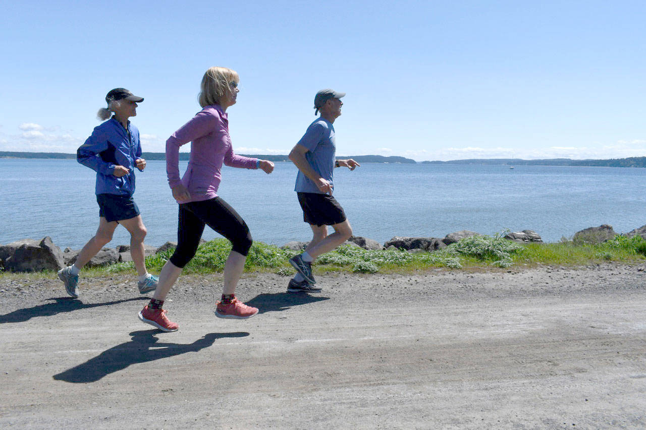 The 40th annual Rhody Run will be held Sunday at Fort Worden State Park. Out for a practice run on the Larry Scott Trail in Port Townsend are Janeann Twelker, Lois Sherwood and Eric Twelker. Sherwood is participating in her 39th event, having broken a foot just before a race several years ago. (Jeannie McMacken/Peninsula Daily News)