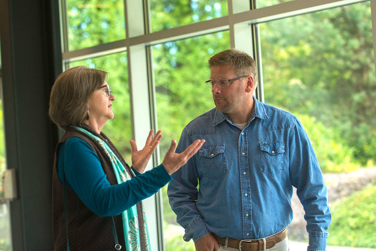 Port Townsend Mayor Deborah Stinson talks with state Rep. Mike Chapman, D-Port Angeles, at Peninsula College on Thursday. (Jesse Major/Peninsula Daily News)