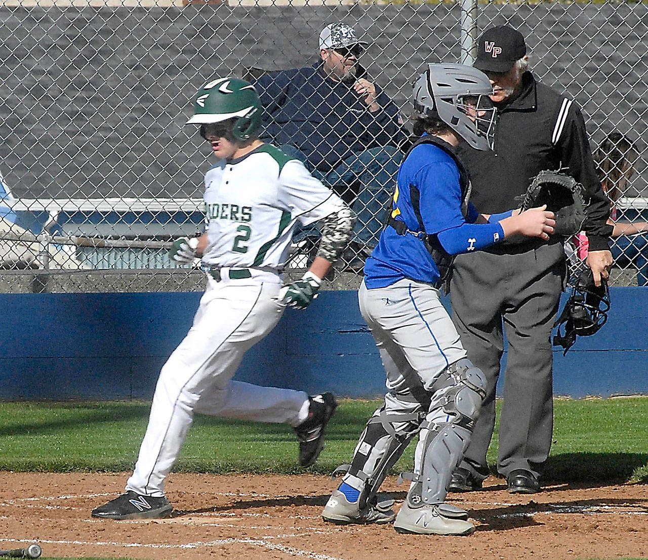 Keith Thorpe/Peninsula Daily News Port Angeles’ Carson Jackson, left, crosses home plate in a March 18 game against Bremerton in Port Angeles.