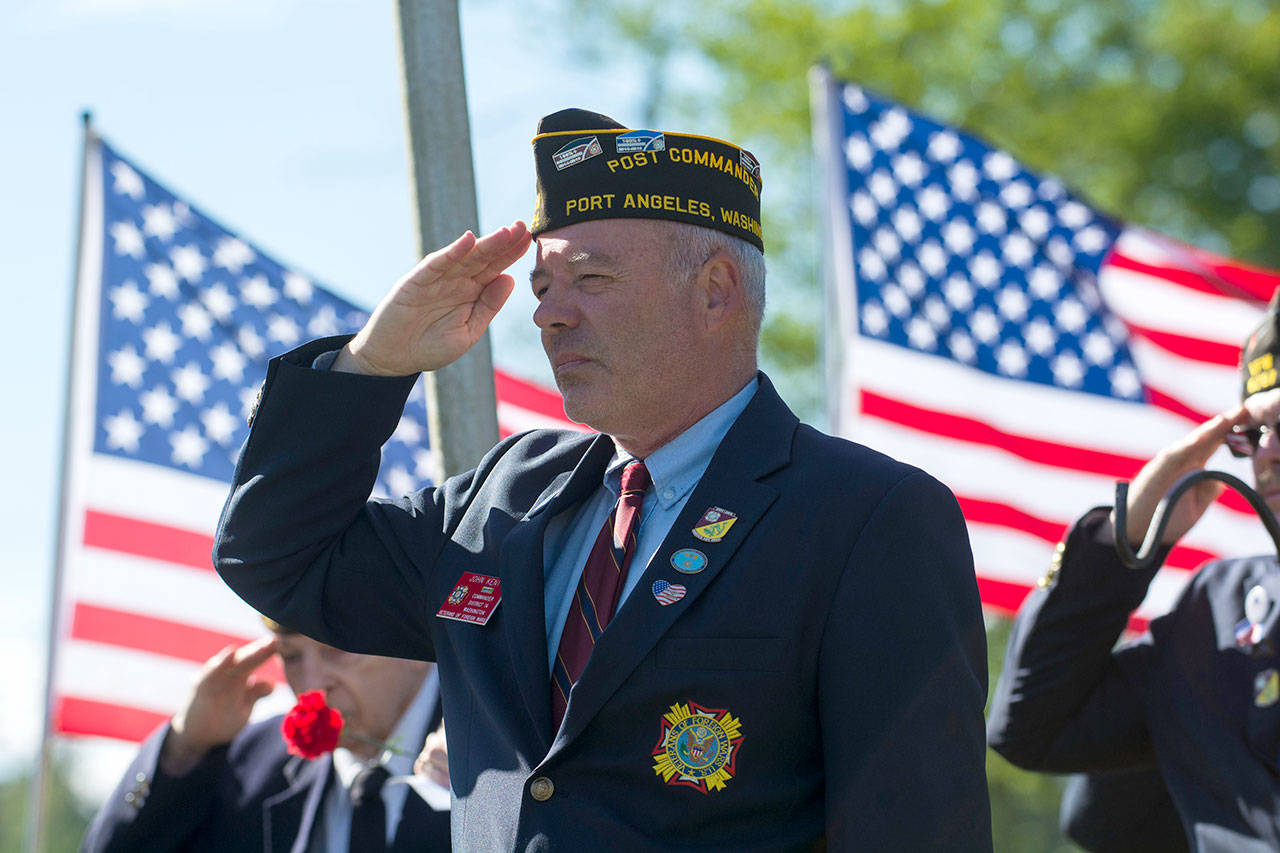John Kent, commander of Veterans of Foreign Wars Post 1024, salutes as The Star-Spangled Banner is sang during the Memorial Day ceremony at Mount Angeles Memorial Park on Monday. (Jesse Major/Peninsula Daily News)