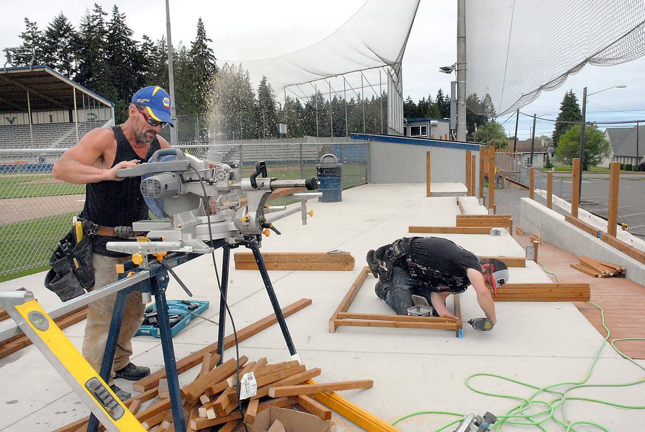Keith Thorpe/Peninsula Daily News Shawn Croft, left, and Lawrence Mitchell, both of J. Oppelt Development & General Contracting, construct railings on Thursday for the “party deck” at Port Angeles Civic Field, part of a series of improvements to the stadium for the Port Angeles Lefties baseball season.