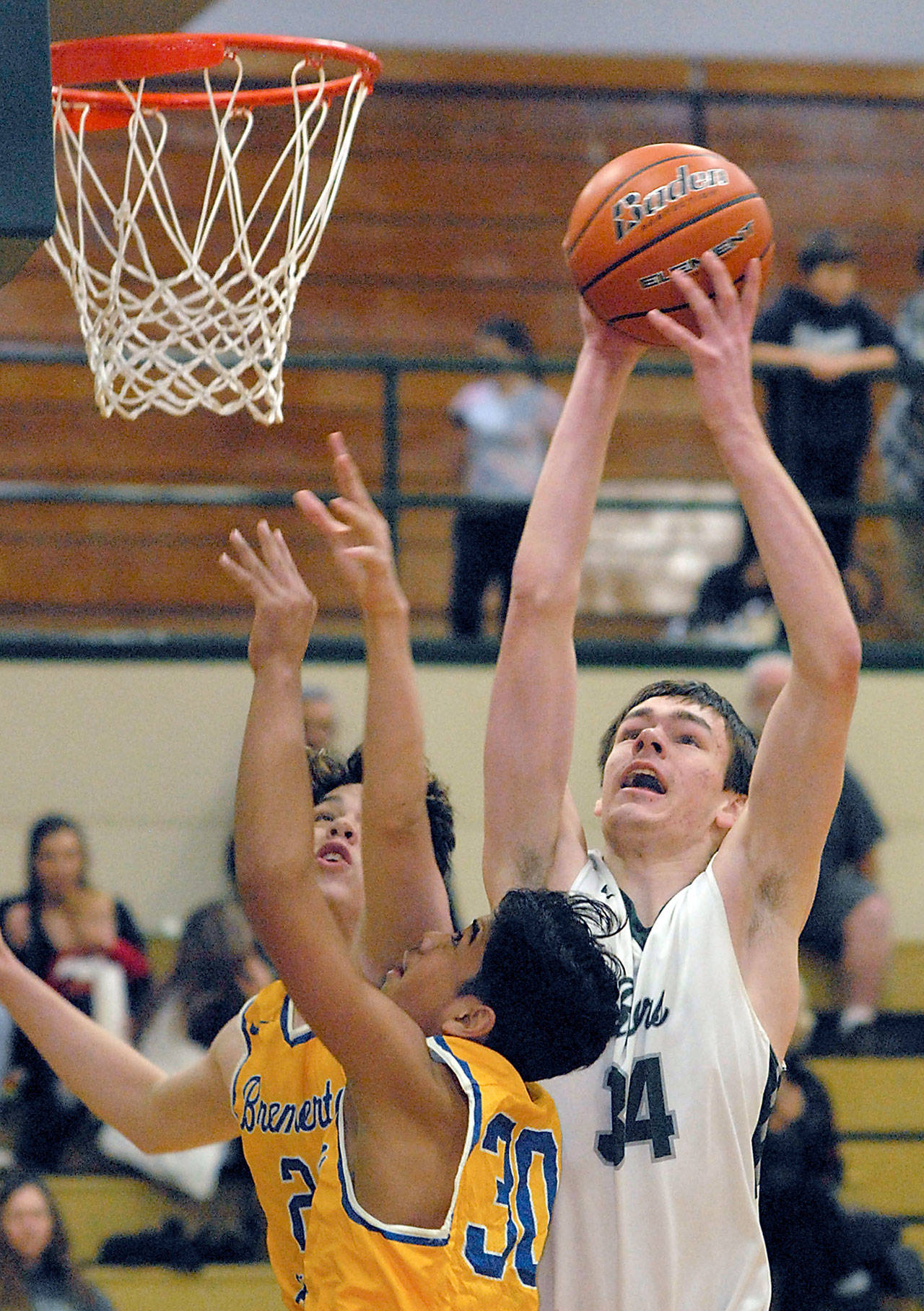 Keith Thorpe/Peninsula Daily News Port Angeles’ Liam Clark, right, takes aim at the basket over the defense of Bremerton’s Gavin King, left, and Kimo Retome during their Jan. 16 game at Port Angeles High School.