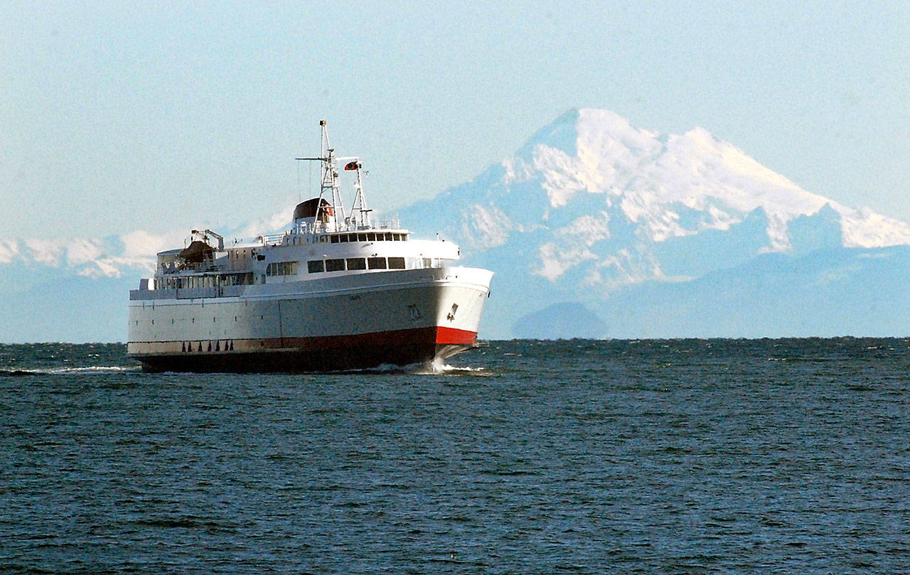 Against a backdrop of Mount Baker, the ferry MV Coho sails into Port Angles Harbor in 2017. (Keith Thorpe/Peninsula Daily News)