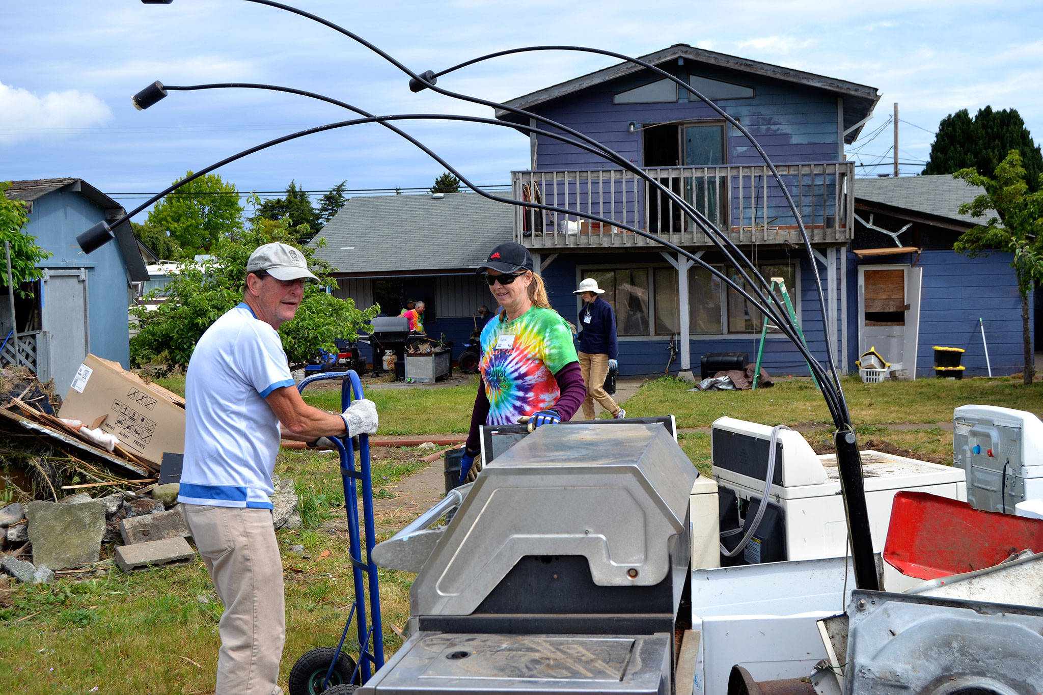 <strong>Matthew Nash</strong>/Olympic Peninsula News Group                                Rick Reed of Dallas, Texas, and Andrea Putnam of Princeton, N.J., move a dryer during Sequim Service Fests first house cleanup Tuesday. Both Reed and Putnam plan to stay and volunteer in Sequim through the events finish Friday, June 15.