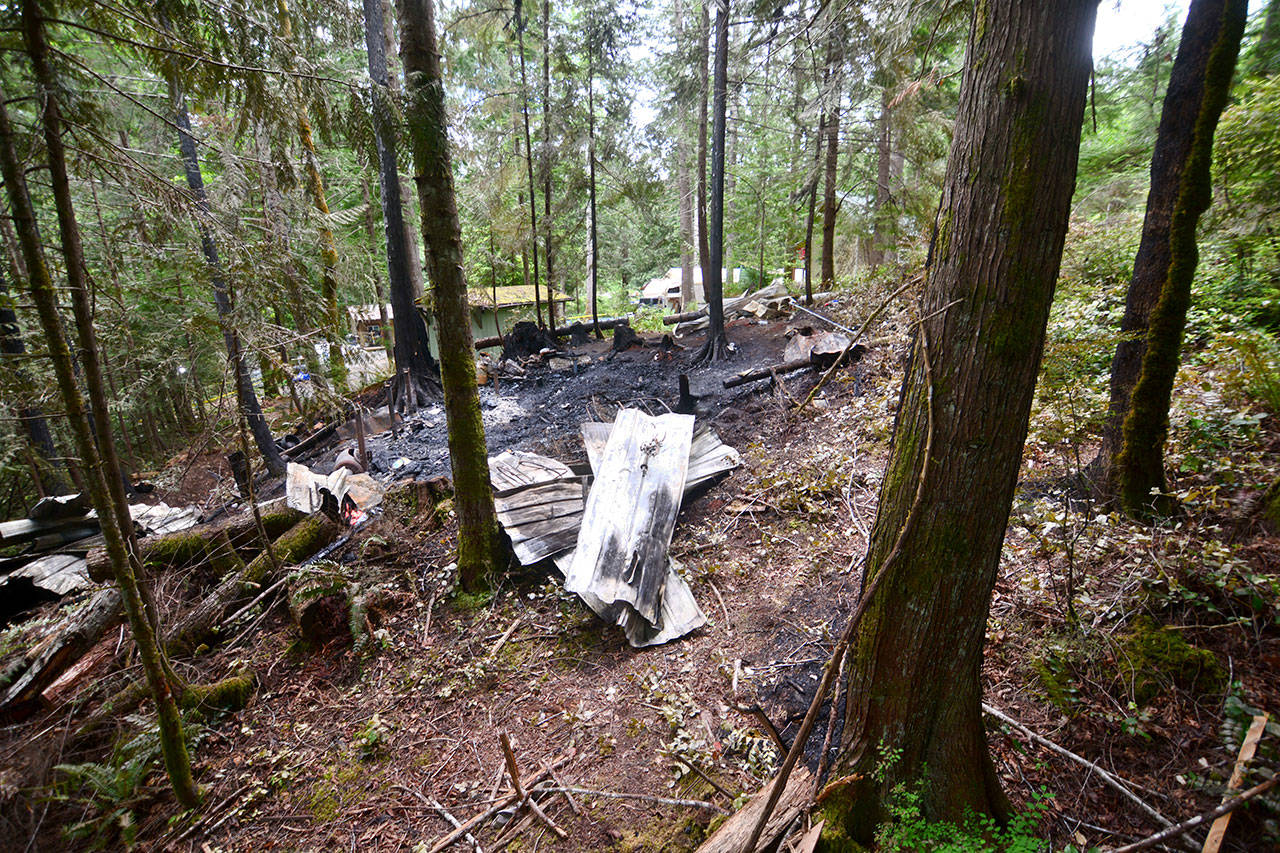 The remains of the cabin that burned in Brinnon on Sunday. A family of five died in the blaze. (Jesse Major/Peninsula Daily News)