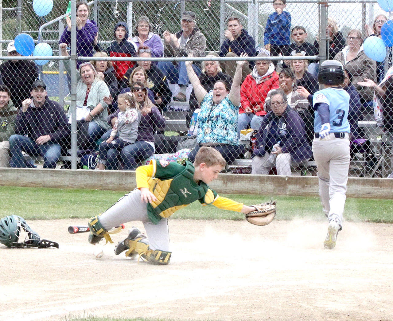 Bryton Amsdill of Swains scored past Laurel Lanes catcher Nathan Basden in the Cal Ripken U12 championship game Thursday. Laurel Lanes rode a big eight-run fifth inning behind a grand slam from Ezra Townsend to win 12-7. (Dave Logan/for Peninsula Daily News)