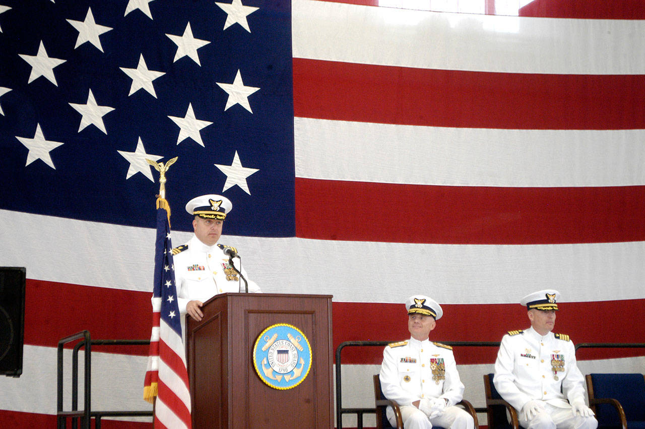 Cmdr. M. Scott Jackson, new commanding officer of Coast Guard Air Station/Sector Field Office Port Angeles, speaks during a change of command ceremony Friday as Rear Adm. David Throop, center, and Capt. Mark Hiigel, right, look on. Jackson assumed command of the base from Hiigel during the ceremony.