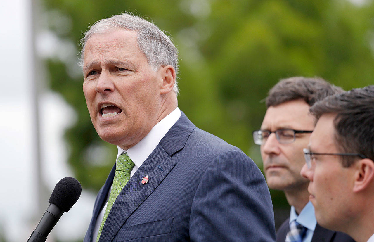 Gov. Jay Inslee, left, speaks as Attorney General Bob Ferguson, center, and Solicitor General Noah Purcell look on at a news conference announcing a lawsuit against the Trump administration over a policy of separating immigrant families illegally entering the U.S. (Elaine Thompson/The Associated Press)