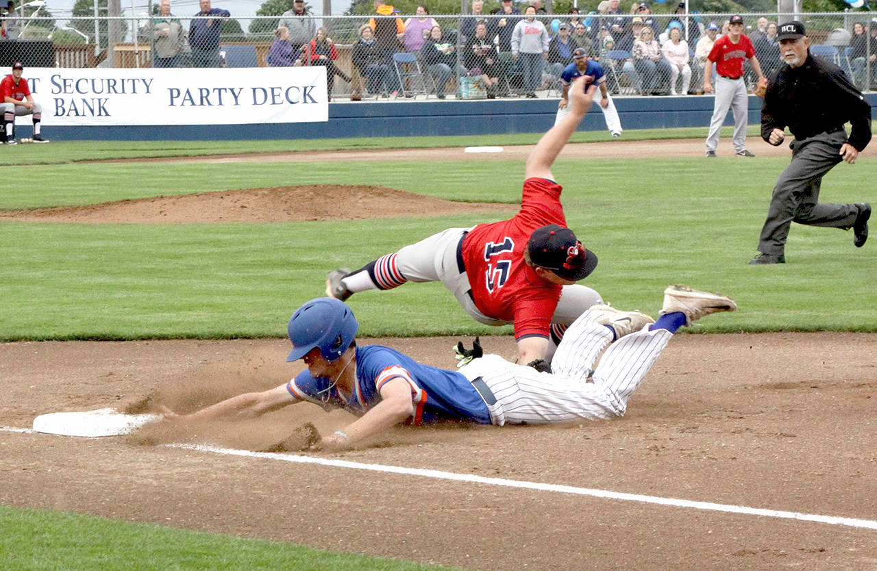 Dave Logan/for Peninsula Daily News Port Angeles’ Trevor Rosenberg, left, dives back to first base while Wenatchee’s Connor McCord applies the tag after an errant throw to the bag from the Apple Sox pitcher.