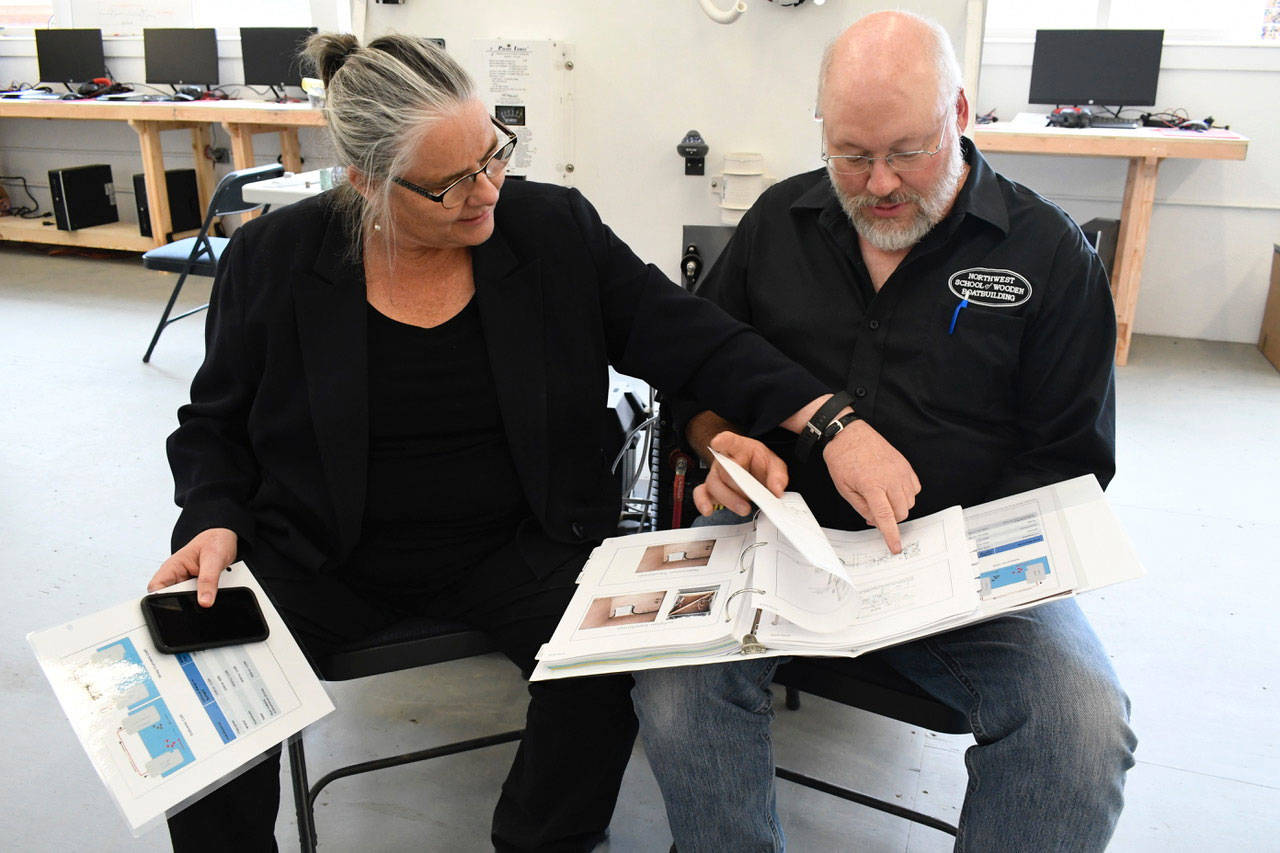 At the Port Hadlock campus of the Northwest School of Wooden Boatbuilding, Executive Director Betsy Davis and Kevin Ritz, lead marine systems instructor, discuss ideas for a pumpout vessel. (Jeannie McMacken/Peninsula Daily News)