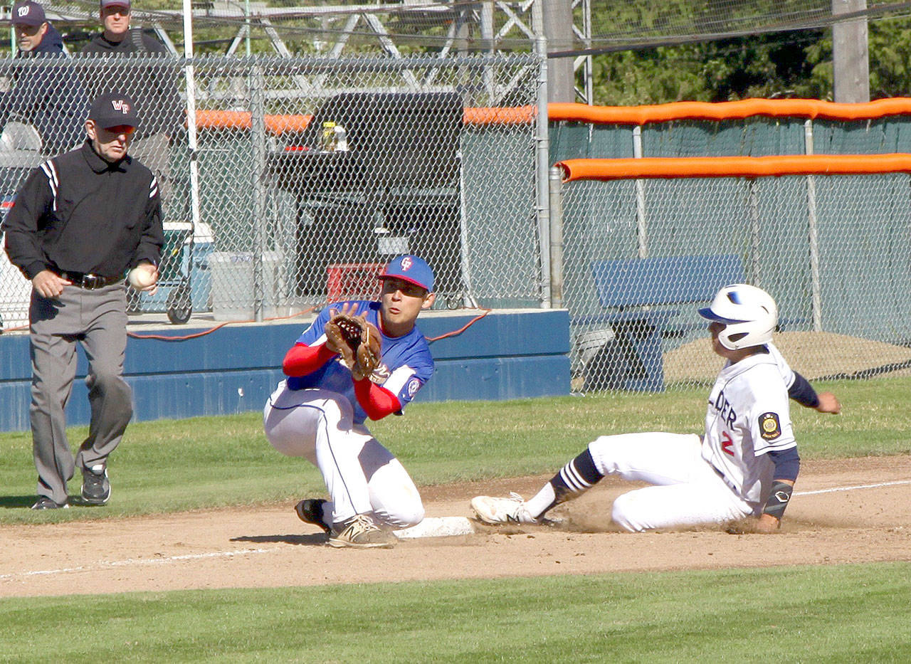 Gavin Guerrero of the Wilder Baseball team slides safely into third base ahead of the throw to the Centerfield Rooster third baseman Nick Laurenza. Guerrero was named the tournament MVP as Wilder beat Centerfield 15-5. (Dave Logan/for Peninsula Daily News).